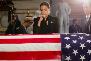 Alexandria Ocasio-Cortez (D-NY) stops to pay her respects over the flag-draped casket of U.S. Rep. Elijah Cummings